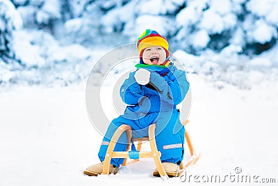 Boy on sleigh ride. Child sledding. Kid with sledge Stock Photo