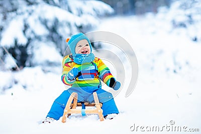 Boy on sleigh ride. Child sledding. Kid with sledge Stock Photo