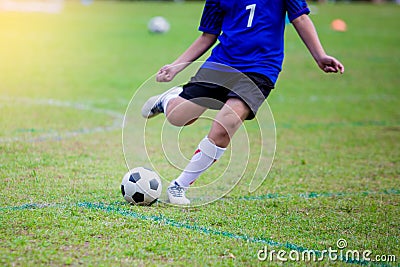 Boy soccer player speed run to shoot ball to goal on green grass Stock Photo