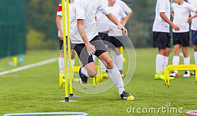 Boy Soccer Player In Training. Boy Running Between Cones During Practice in Field Stock Photo