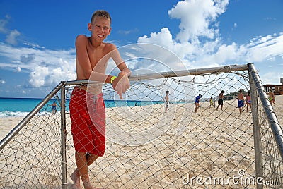 Boy standing at beach goalpost Stock Photo