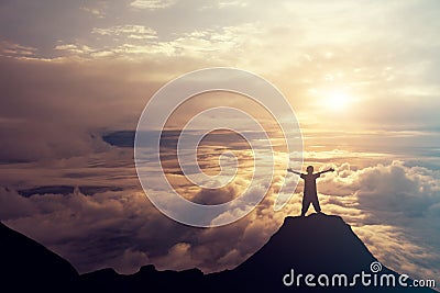 A boy standing on the top of the mountain above the clouds. Success Concept. Stock Photo