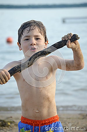 Boy with Stick at Beach Stock Photo