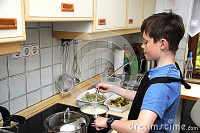 Boy stirring sauce Stock Photo