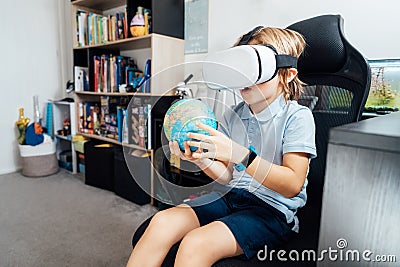Boy studies space with help of technology and app. Kid in Virtual reality headset learning Solar system planets at home Stock Photo