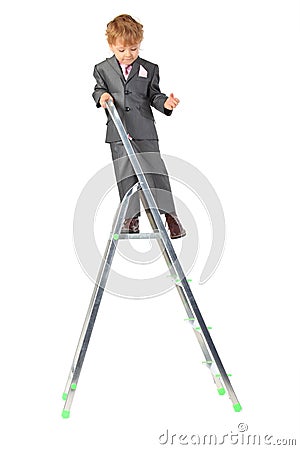 Boy in suit on step-ladder top Stock Photo