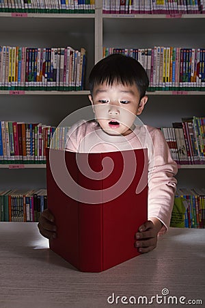 Boy Surprised By Glowing Book Stock Photo