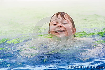 Boy is swimming in an warm outside pool Stock Photo