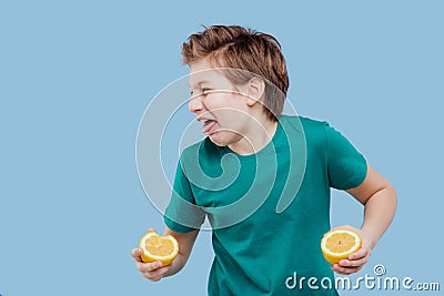 Boy taste a fresh lemon, sour taste, make grimace, Stock Photo