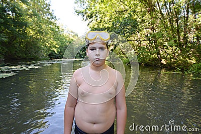 Boy teenager swims in river in summer Stock Photo