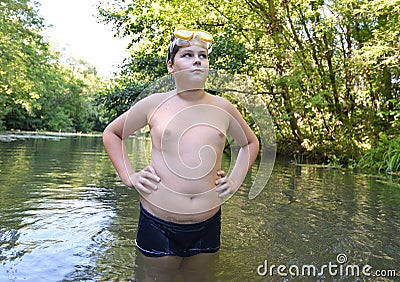 Boy teenager swims in river in summer Stock Photo