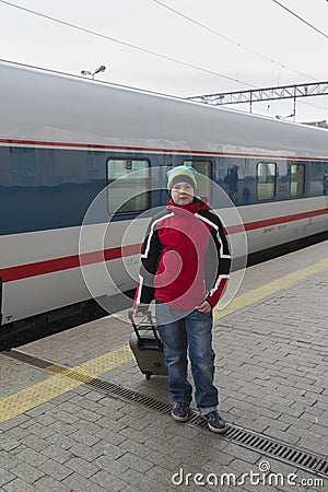 Boy teenager with travel bag near a train Stock Photo