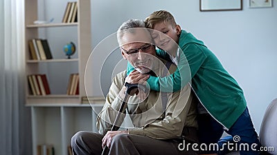 Boy tenderly embracing grandfather, family love, respect for older generation Stock Photo