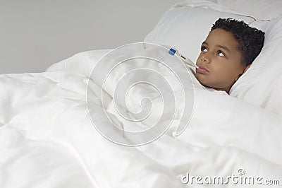 Boy With Thermometer Lying In Bed Stock Photo