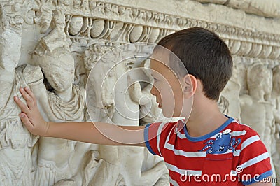 A boy touches historical monument Stock Photo