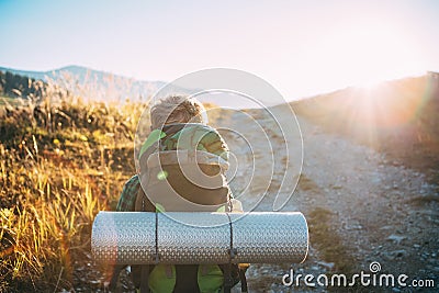 Boy tourist backpacker walk ob sunny road Stock Photo