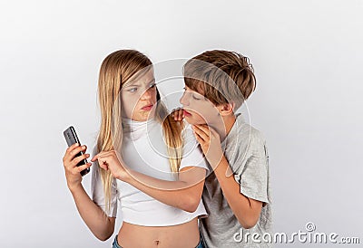 Boy trying to spy a girl`s mobile phone but the girl noticed it Stock Photo