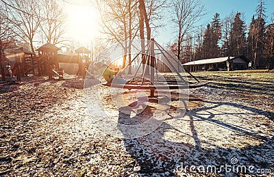 Boy turns on carousel on playground at deep autumn time Stock Photo