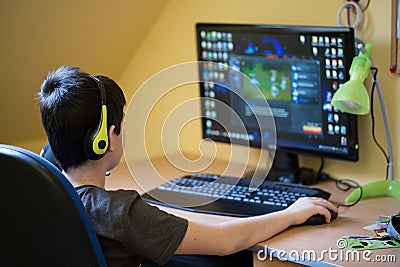 Boy using computer at home, playing game Stock Photo