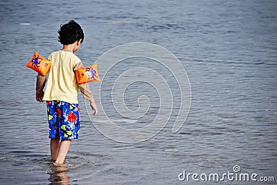 Boy walking in the sea Stock Photo