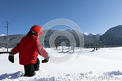 A boy walks through deep friable snow in the winter Stock Photo