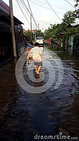 a boy was playing with the flood water that inundated a settlement Stock Photo