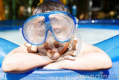 A boy in a water mask near the pool with his eyes closed Stock Photo