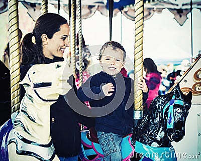 Boy Waving on a Carousel Ride with Mother - Retro Stock Photo