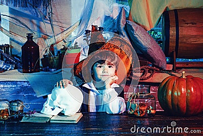 Boy wearing Halloween costume with pumpkin an old wooden house. Happy Halloween Cute little boy making funny faces with Stock Photo