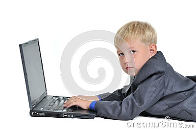 Boy wearing suit working on laptop Stock Photo