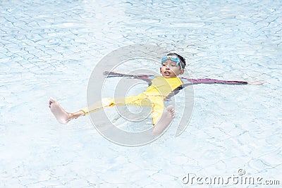 A boy wearing a swimsuit that floats in water. It is a practice of survival skills even if you can`t swim. Stock Photo