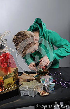Boy wrapping up christmas gifts Stock Photo