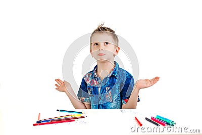 A boy of 6 years in a blue shirt makes a gesture on a white background isolate. The concept is not innocent, does not know Stock Photo