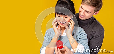 Boyfriend ask asian girlfriend for marrying him by giving diamond ring. Asia woman get surprised, happiness. Handsome caucasian ma Stock Photo