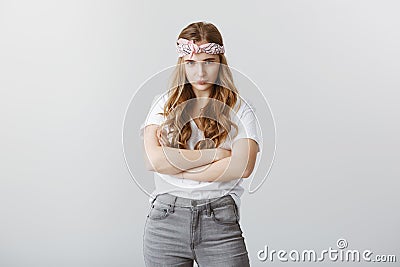 Boyfriend broke promise. Indoor shot of offended cute creative girl with blond hair in headband, crossing hands and Stock Photo