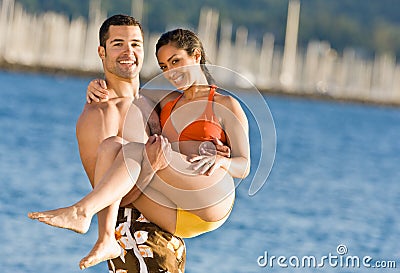 Boyfriend carrying girlfriend at beach Stock Photo