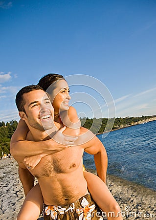 Boyfriend carrying girlfriend at beach Stock Photo