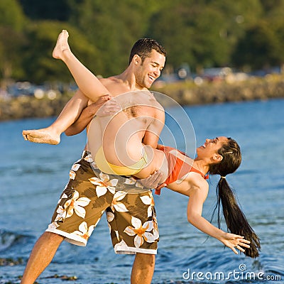 Boyfriend carrying girlfriend at beach Stock Photo