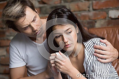 Husband hugging comforting sad crying spouse Stock Photo