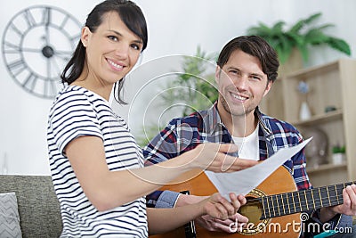 boyfriend playing guitar song from sheet music Stock Photo