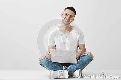 Boyfriend wants to show his couple something in laptop. Portrait of good-looking young bearded student in stylish Stock Photo