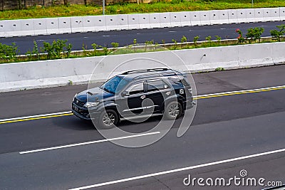 Black Toyota Fortuner diesel SUV driving fast on Trans Jawa highway Editorial Stock Photo