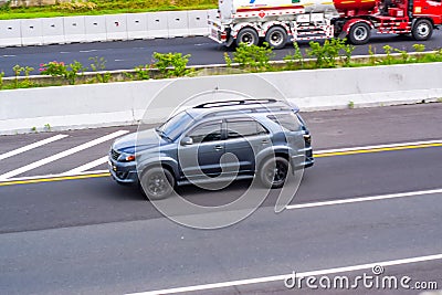 Grey Toyota Fortuner SUV driving fast on Trans Jawa highway Editorial Stock Photo