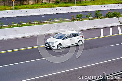 White Toyota Yaris hatchback XP130 driving fast on trans jawa highway Editorial Stock Photo