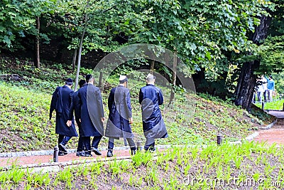 Boys Hasidic Jews, in traditional black clothes walk in the park in Uman, Ukraine, the time of the Jewish New Year, Religious Editorial Stock Photo
