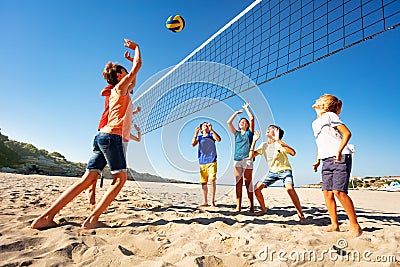 Boys and girls playing volleyball on the beach Stock Photo