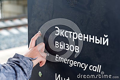Boys hand presses the emergency call button at station Stock Photo