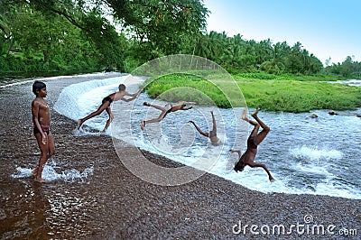 Boys jumping on lake water Editorial Stock Photo