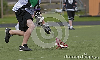 Boys Lacrosse scooping up the ball Stock Photo