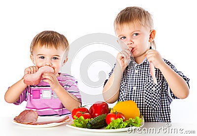 Boys and plates of vegetables and meat Stock Photo